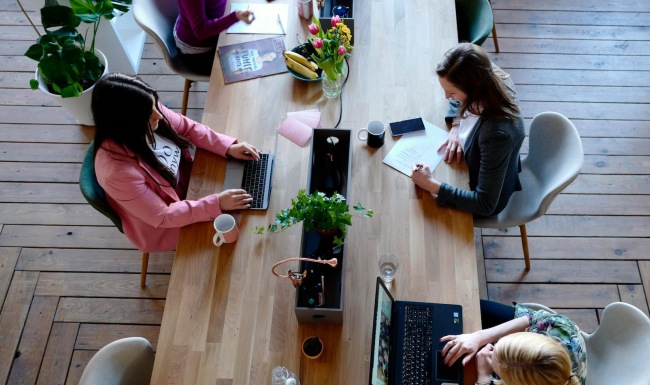people working on computers at a large table